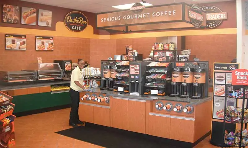 Convenience store coffee center with employee.